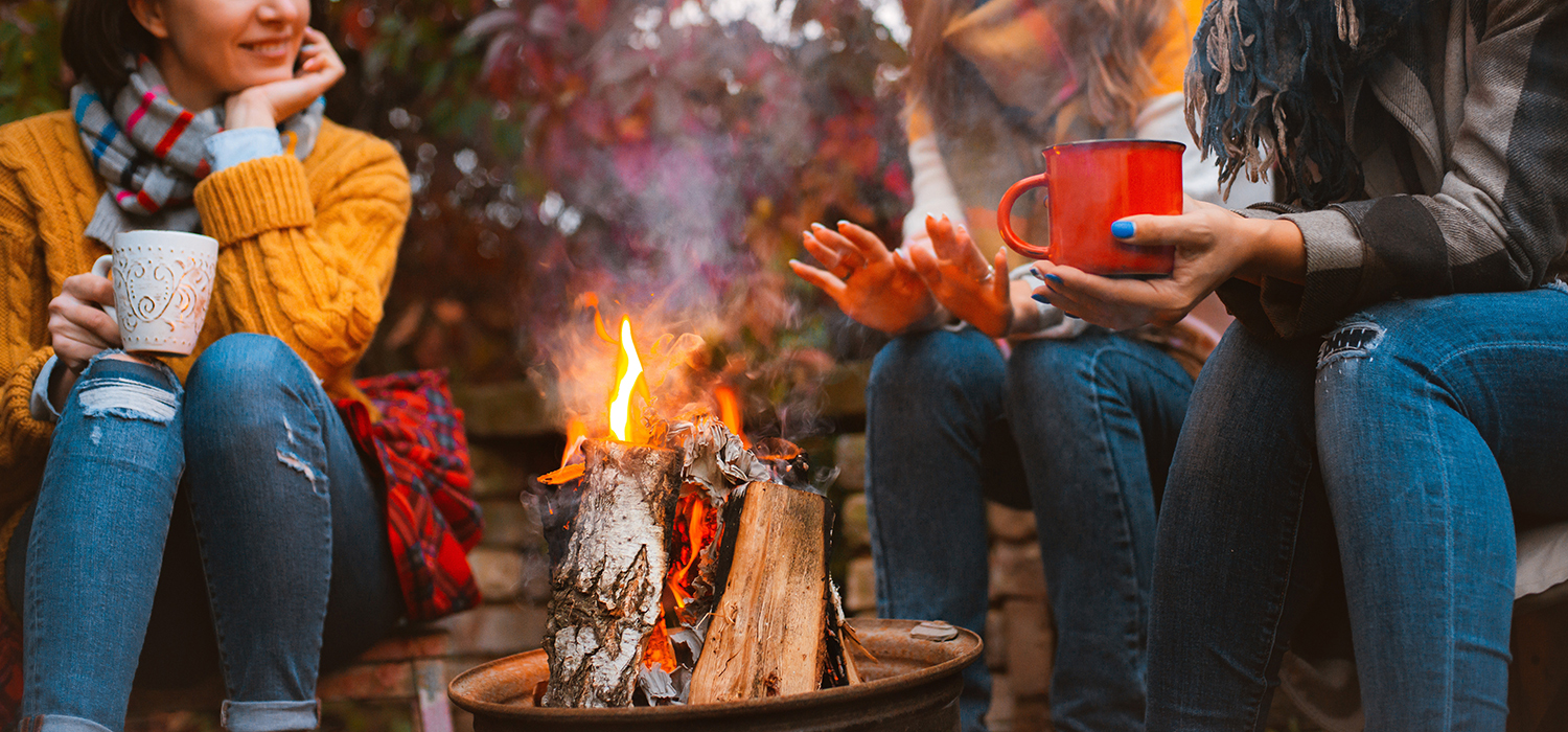 Campers sitting arounf a camp fire at Sussex Campsite