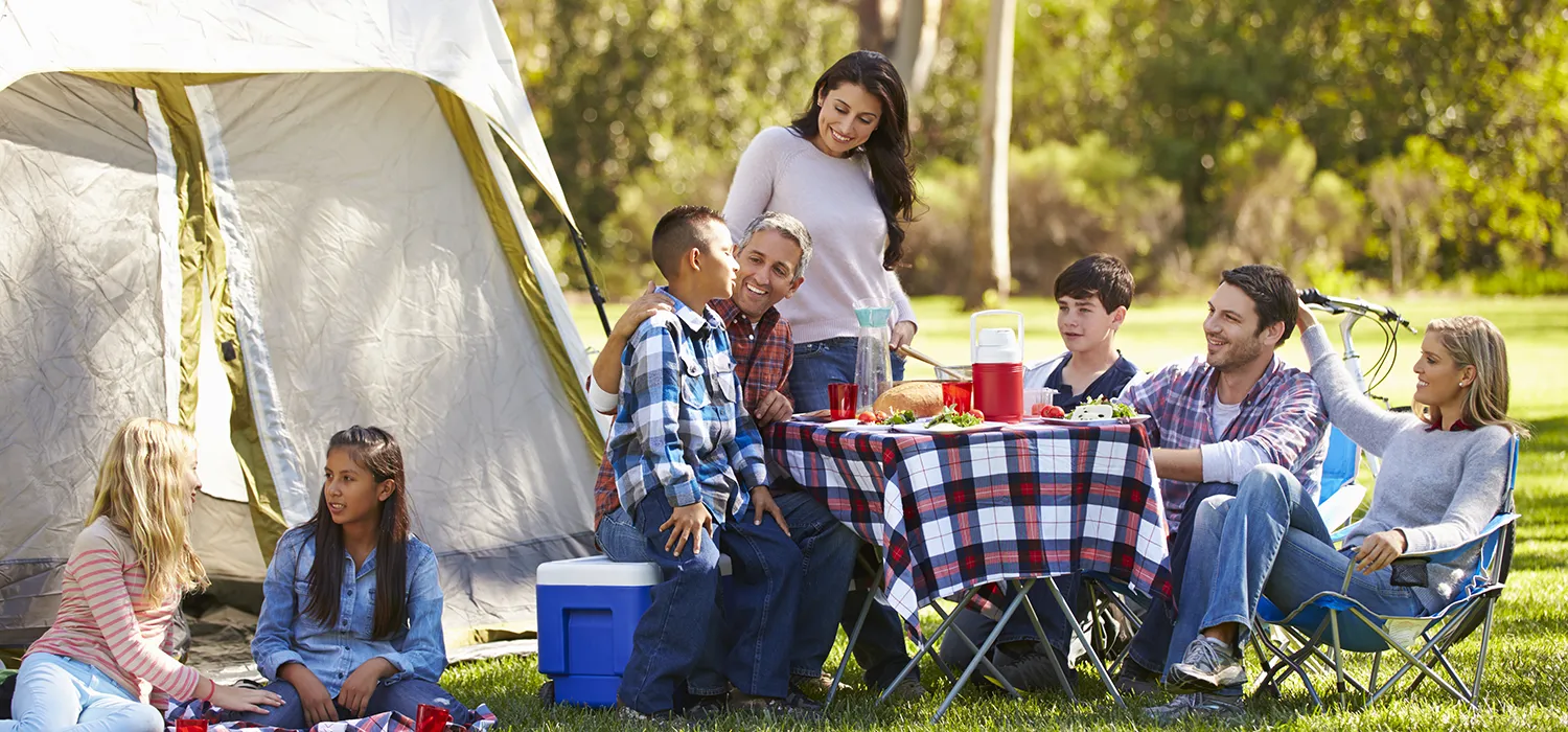 Campers sitting arounf a camp fire at Sussex Campsite